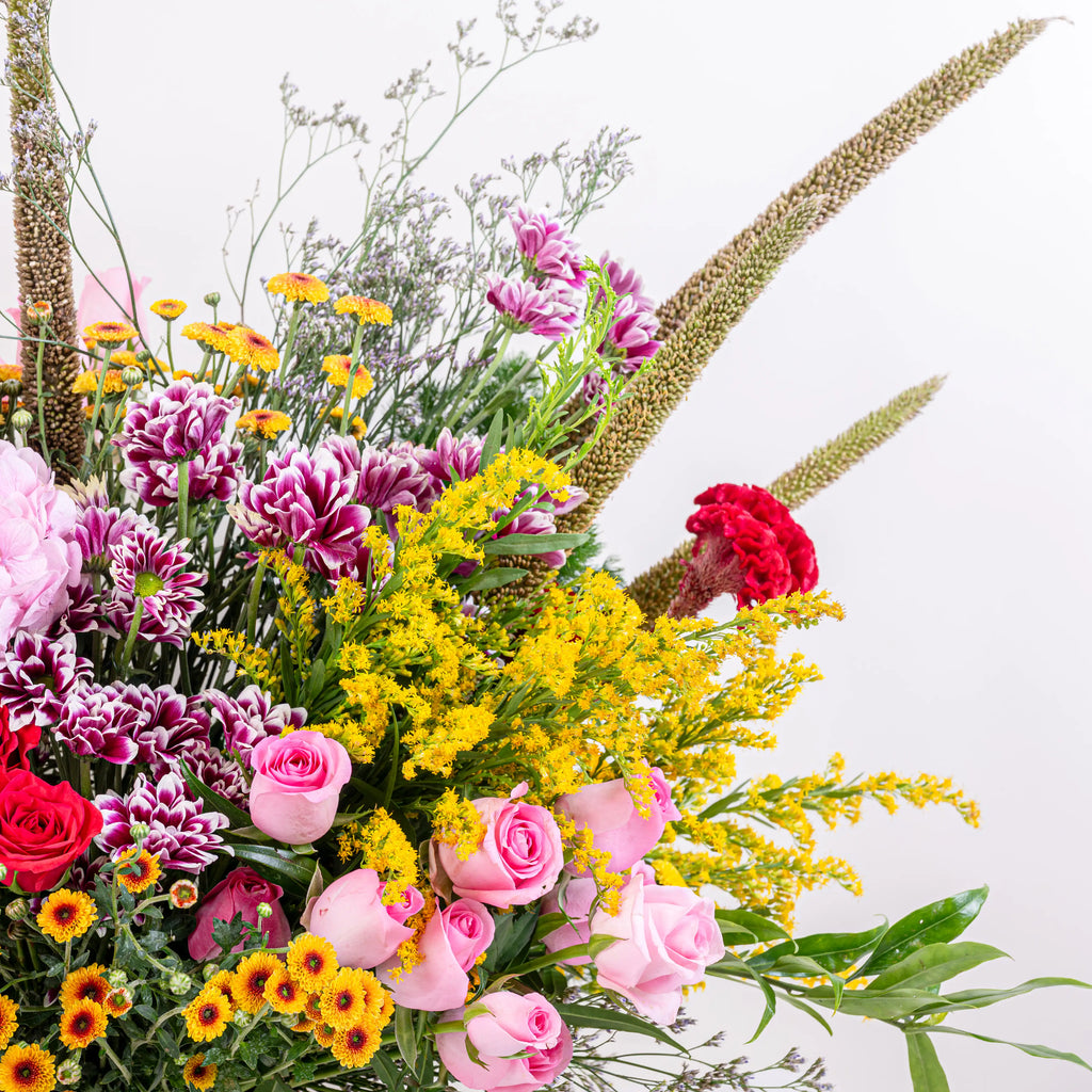 Blush and Flame red and pink floral arrangement with red roses and pink blooms in premium container by House of Mograa