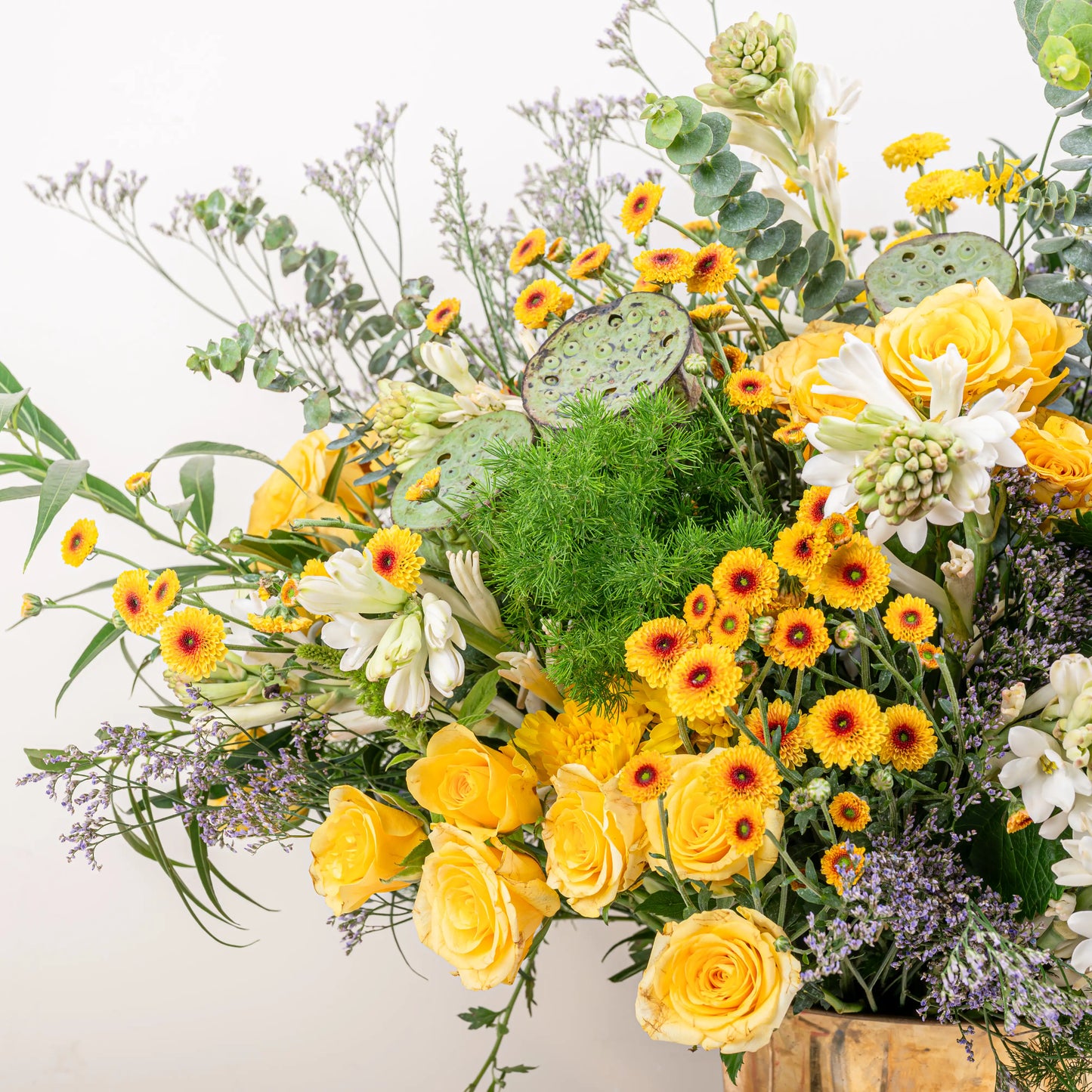 Citrus & Ivory luxury centerpiece with yellow roses, white hydrangea, gerberas, tuberose and eucalyptus in gold geometric vase by House of Mograa