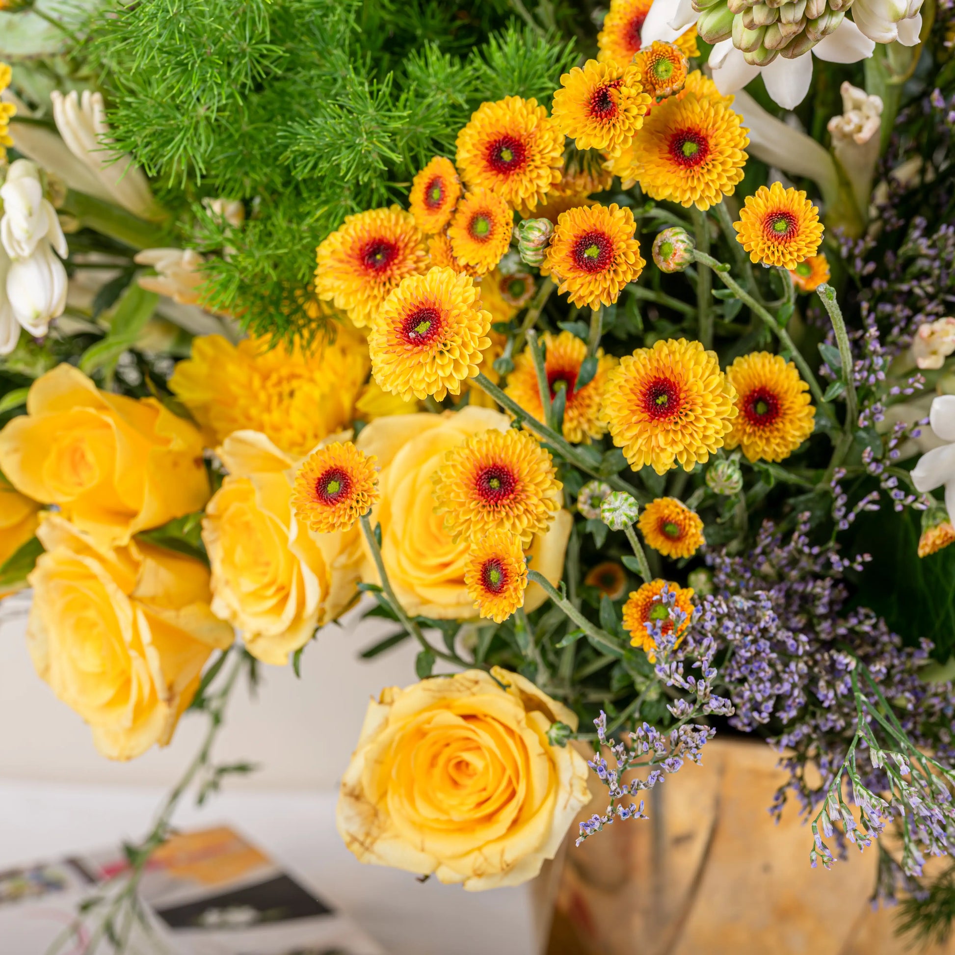 Citrus & Ivory luxury centerpiece with yellow roses, white hydrangea, gerberas, tuberose and eucalyptus in gold geometric vase by House of Mograa