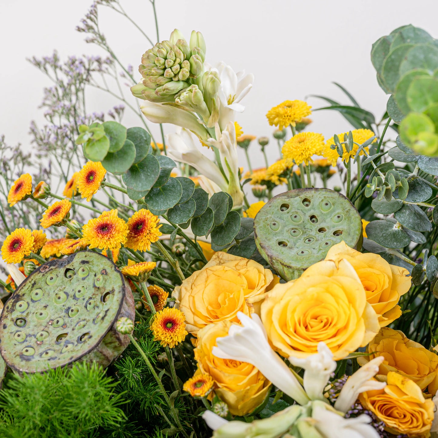 Citrus & Ivory luxury centerpiece with yellow roses, white hydrangea, gerberas, tuberose and eucalyptus in gold geometric vase by House of Mograa
