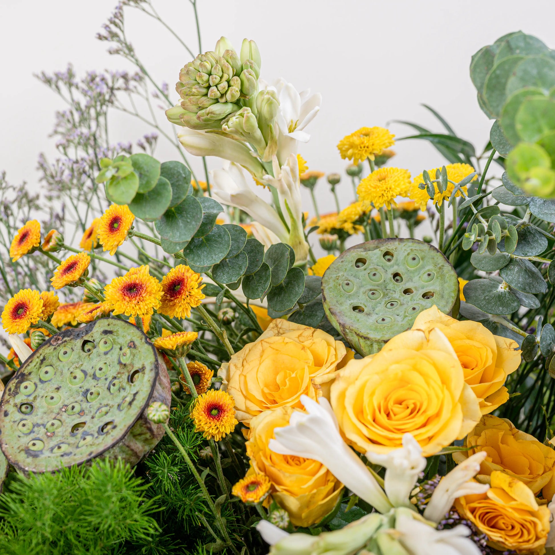 Citrus & Ivory luxury centerpiece with yellow roses, white hydrangea, gerberas, tuberose and eucalyptus in gold geometric vase by House of Mograa