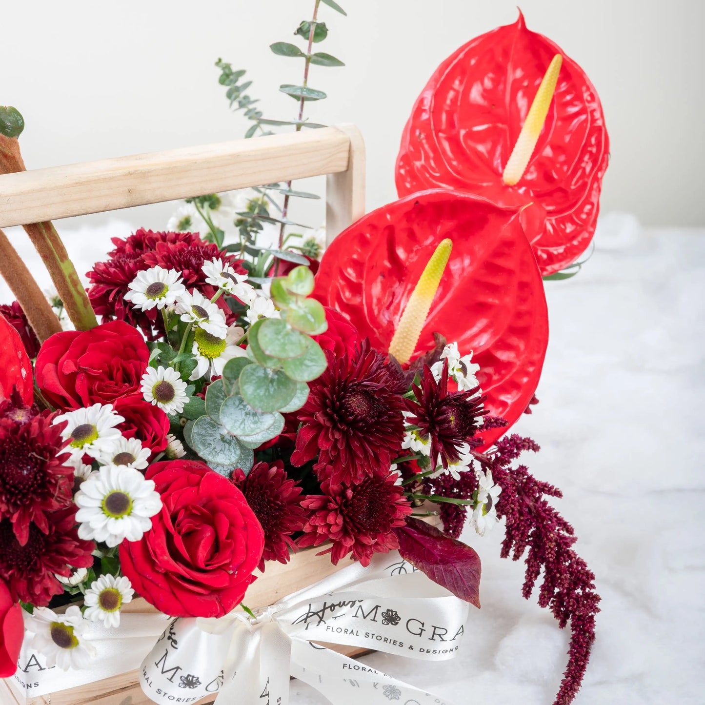 Crimson Fusion red rose and red anthurium mixed arrangement with greenery by House of Mograa