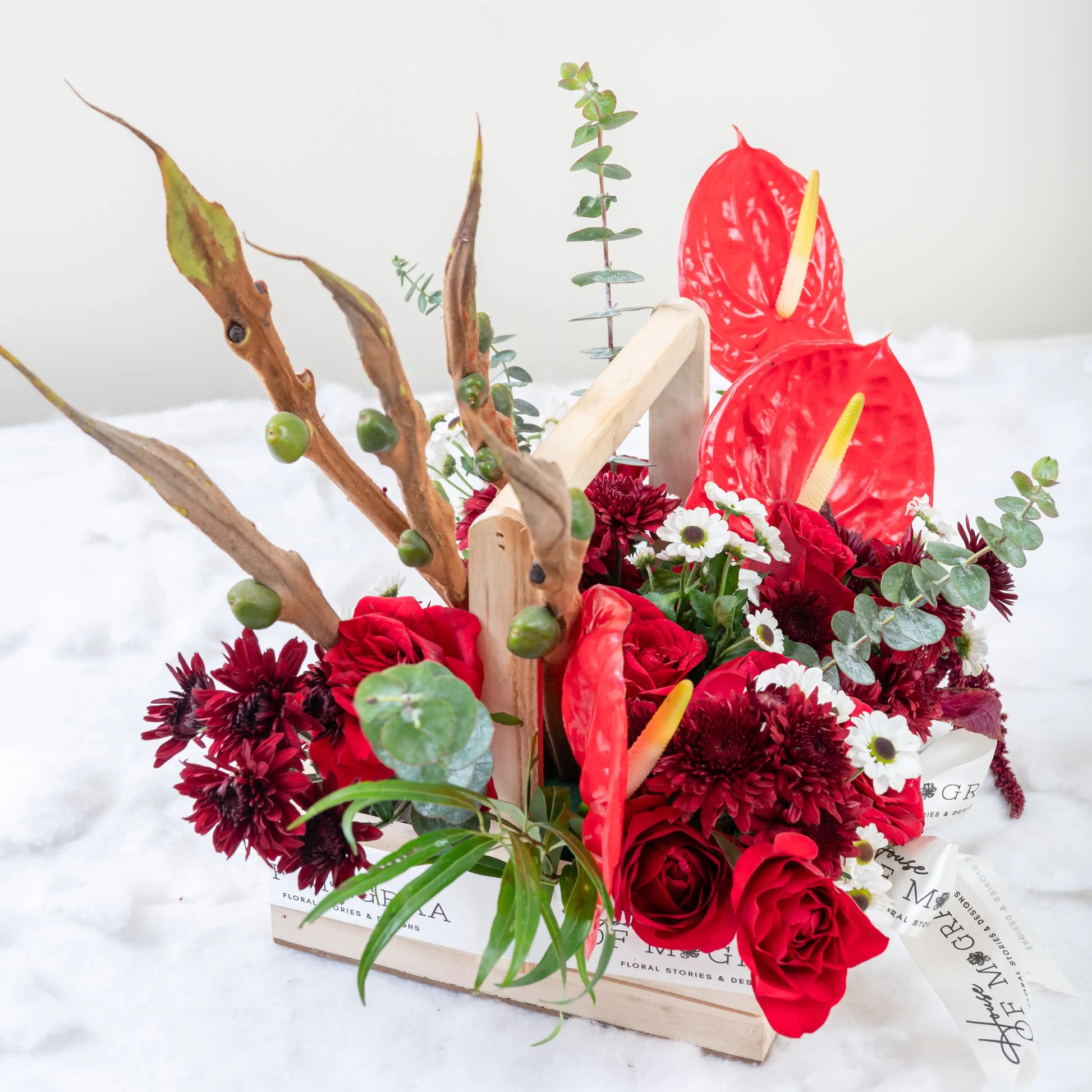 Crimson Fusion red rose and red anthurium mixed arrangement with greenery by House of Mograa