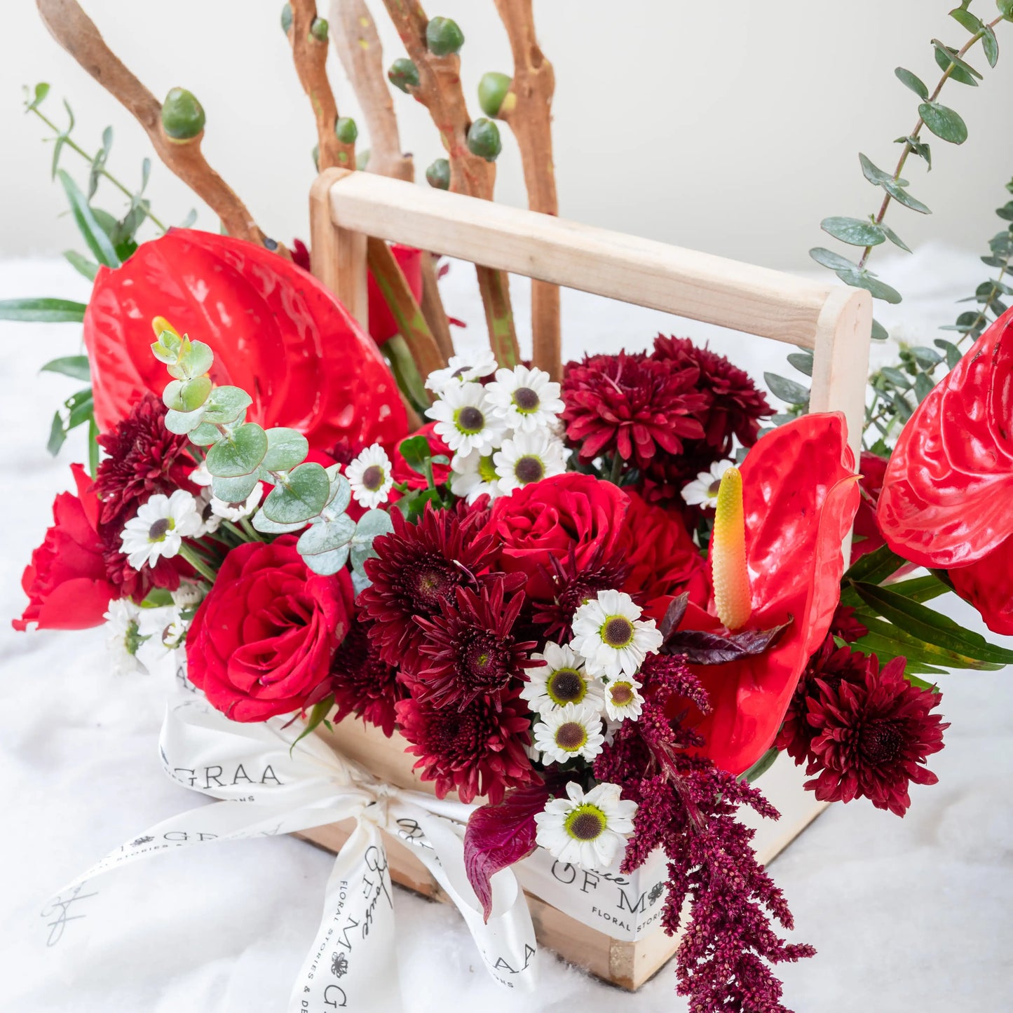 Crimson Fusion red rose and red anthurium mixed arrangement with greenery by House of Mograa