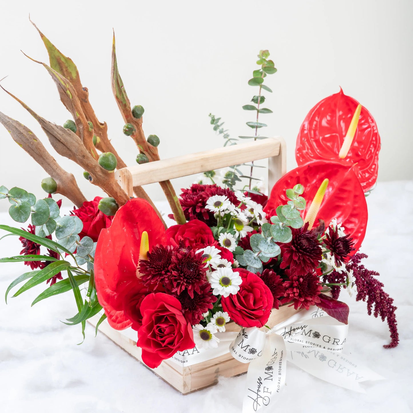 Crimson Fusion red rose and red anthurium mixed arrangement with greenery by House of Mograa