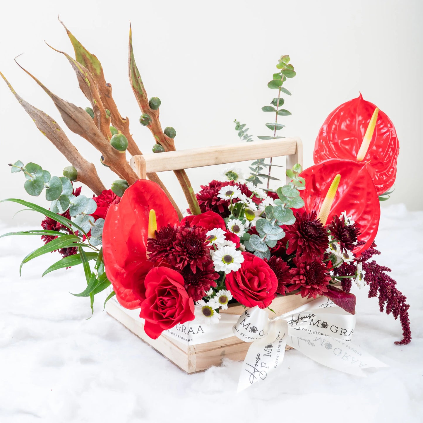 Crimson Fusion red rose and red anthurium mixed arrangement with greenery by House of Mograa