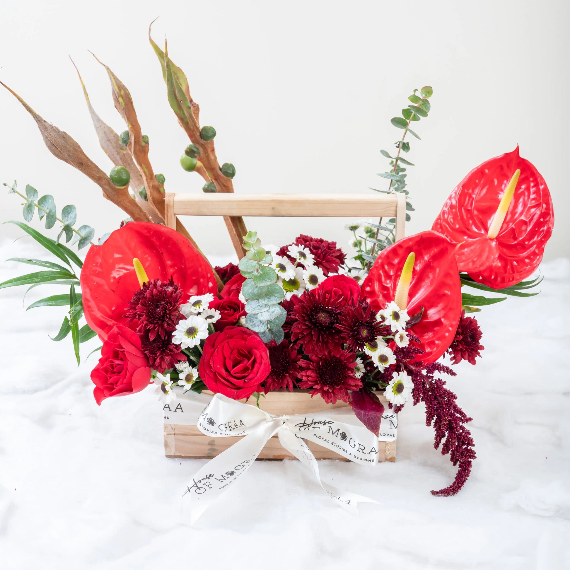 Crimson Fusion red rose and red anthurium mixed arrangement with greenery by House of Mograa