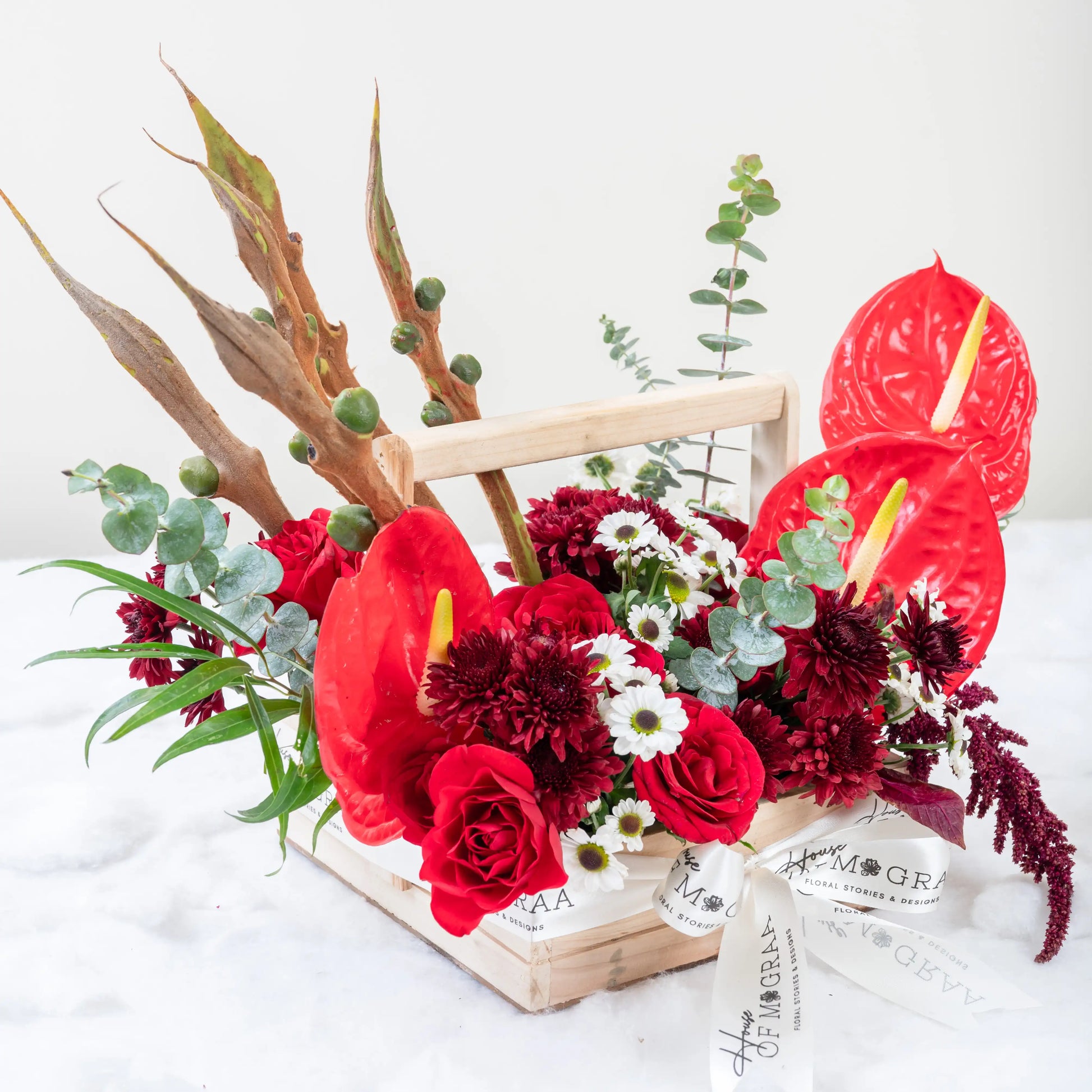 Crimson Fusion red rose and red anthurium mixed arrangement with greenery by House of Mograa
